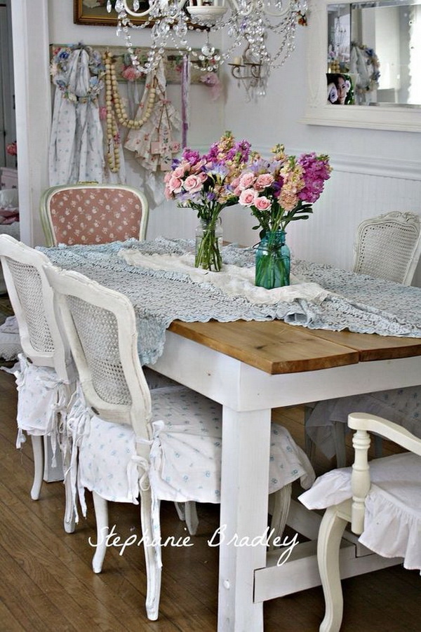 Shabby chic dining room with fresh flowers in mason jars and gorgeous chandelier. 