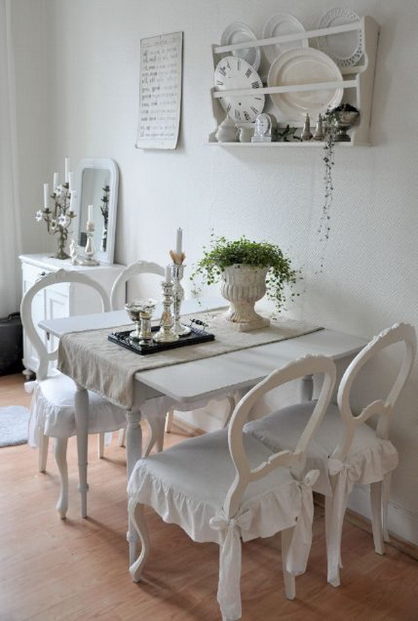 All vintage white shabby chic dinning area with a wall shelving system. 