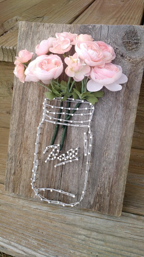 Rustic Mason Jar String Art. Make a unique piece of decor with fake flowers and string! Great Mother's Day Gift and country chic home decor.